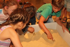 Kinds in Sand box looking Felix
